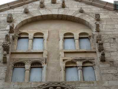 ...racchiuso da un grande arco che include due coppie di piccole bifore, stupisce per le grottesche figure di animali che lo incorniciano